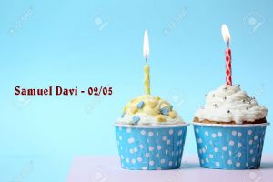 Delicious birthday cupcake on table on light blue background